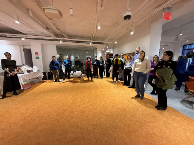 Reception guests standing in a wide circle in a LabCentral common area