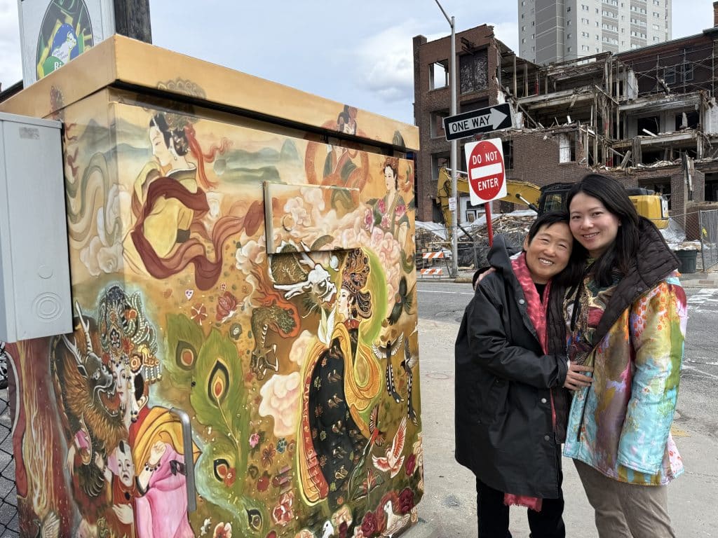 Xiang Li and Fei Wu standing in front of their WooBox in Worcester